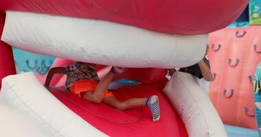 Kids playing on colorful inflatable obstacle course video