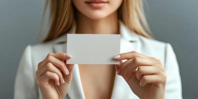 A woman in a business suit holding a blank card photo