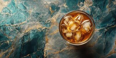 An ice cold glass of iced tea on a marble surface photo