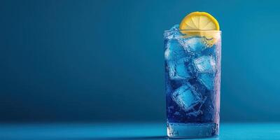 Refreshing blue drink with lemon slice and ice cubes on a vibrant blue background photo