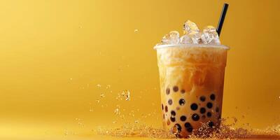 Refreshing bubble tea with ice on a vibrant yellow background, showcasing a popular drink at a cafe setting photo