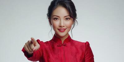 Woman in a red traditional dress gesturing confidently with a smile against a light background photo