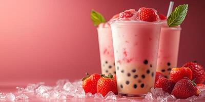 Refreshing strawberry bubble tea served in clear cups with fresh strawberries on a pink background photo