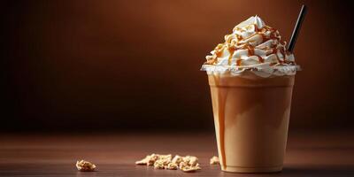 Creamy caramel frappuccino topped with whipped cream and drizzle served in a clear cup on a wooden table photo
