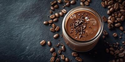 Delicious chocolate coffee drink served in a glass jar with coffee beans scattered on a dark surface photo