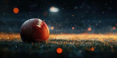 Football resting on wet grass illuminated by stadium lights during a rainy evening match photo