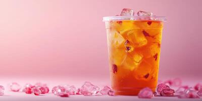Refreshing beverage in a transparent cup filled with ice and pink stones on a pastel background photo