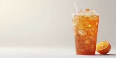 Refreshing iced tea served in a clear cup with a slice of orange beside it on a light background photo