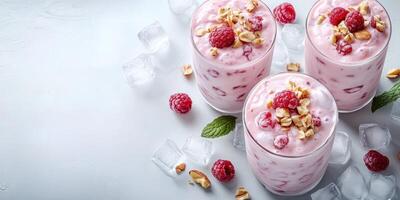 Refreshing raspberry yogurt parfaits topped with granola and mint on a light background photo