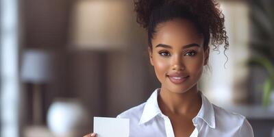 Woman with natural curly hair holds a blank card in a well-lit modern interior setting during the daytime photo