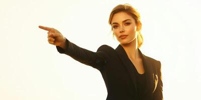 Young woman in a black suit pointing towards the horizon during sunset in an urban environment photo