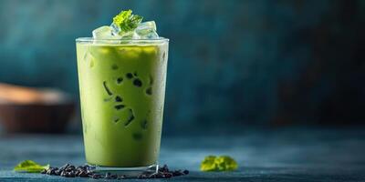 Refreshing iced green drink with mint garnishing served in a transparent glass on a dark surface photo