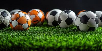 Multiple soccer balls of different designs arranged on a lush green artificial turf photo