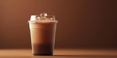 Iced beverage in a clear cup with ice against a textured brown backdrop in a minimalistic setting photo