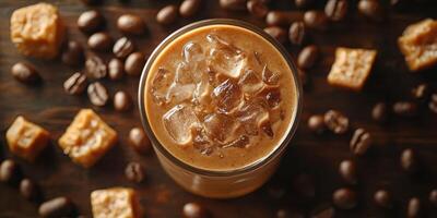 Refreshing iced coffee with caramel bites and coffee beans on a wooden surface photo