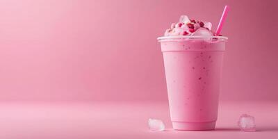 Freshly blended pink milkshake garnished with whipped cream and strawberries on pastel background photo