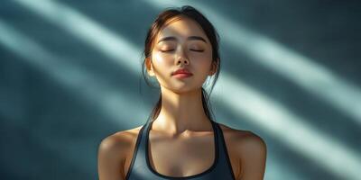 Young woman practicing mindfulness in a sunlit room with shadows in the background during the morning hours photo