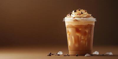 Iced coffee drink with cream and chocolate topping served in a clear cup on a brown background photo