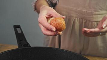 Housewife carefully rolls up her hands and forms round meat ball. She then places it on hot frying pan and presses it against it to give it flat shape, creating patty. video