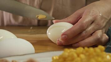 A chicken egg has been cut into thin slices on a cutting board in the kitchen, which will be used to make a salad. video