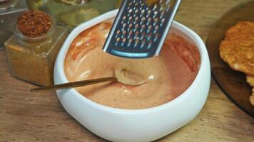 To make delicious, juicy red sauce for hamburgers, which is mixture of mayonnaise, ketchup and sour cream, cook grates pickled cucumber and add it to dressing. video