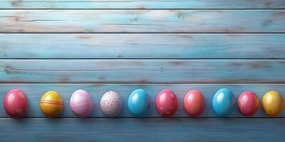 Colorful easter eggs arranged in a neat row on a rustic blue wooden surface during springtime photo