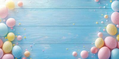 Colorful Easter eggs arranged on a blue wooden backdrop with pastel decorations spread across the surface photo
