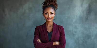 Confident businesswoman standing with arms crossed in modern office setting during daytime photo