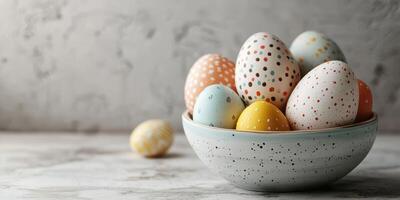 Colorful decorated eggs in a bowl on a textured surface for a festive spring celebration photo