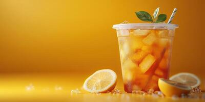 Refreshing iced tea served with lemon slices and mint leaves on a vibrant yellow background photo