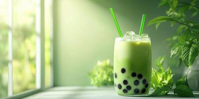 Refreshing green tea bubble drink served in a glass with ice in a bright, nature-inspired setting photo