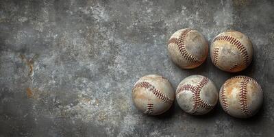 Collection of worn baseballs arranged on a textured surface in soft lighting during the day photo