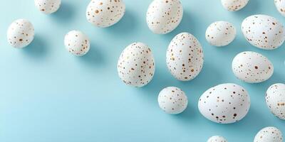 Decorative white eggs with golden speckles arranged on a light blue surface, ideal for a festive celebration or craft project photo