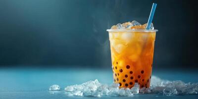 Refreshing iced tea drink with tapioca pearls and ice on a blue background photo