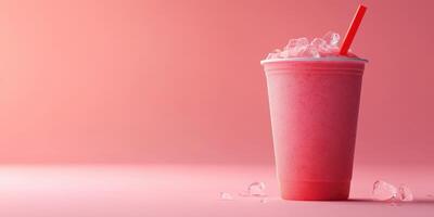 Refreshing berry smoothie served in a clear cup with ice and a red straw against a soft pink background photo