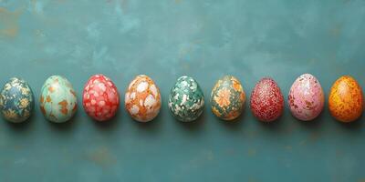 Colorful decorated eggs arranged in a row on a textured blue background photo