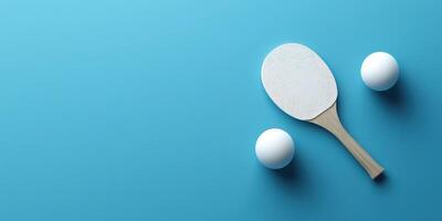 Table tennis paddle and two balls on a vibrant blue background ready for a game photo