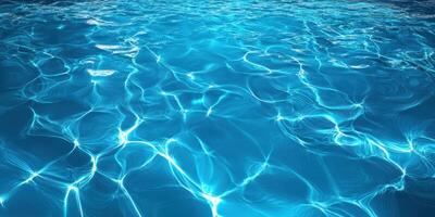 Rippling clear blue water glimmers under sunlight revealing beautiful patterns and reflections in a serene aquatic environment photo