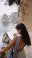 woman walks down the stairs to Diamond Beach on Nusa Penida. vertical video