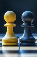 Two chess pawns, one yellow and one black, face each other on board, symbolizing competition and strategy photo