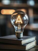 glowing light bulb with letter inside, resting on books, symbolizes creativity and inspiration photo