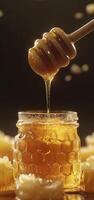 Delicious honey dripping from wooden dipper into glass jar, surrounded by honeycomb photo
