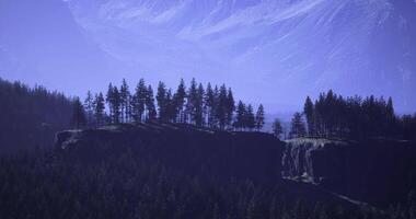 Twilight sky over tree covered cliffs in a mountainous landscape video