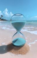 hourglass with blue sand on beach, symbolizing time and tranquility photo