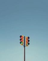 yellow traffic light stands tall against clear blue sky, signaling caution photo