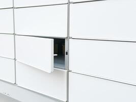 Open locker in a modern white parcel locker system for delivery and storage photo
