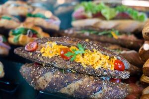 Fresh whole grain panini sandwich with cheddar cheese and cherry tomatoes in a bakery display. photo