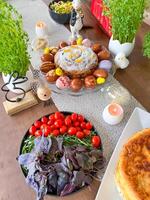 Easter festive table with traditional cake, dyed eggs, and fresh vegetables photo