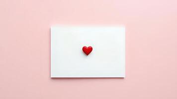 White greeting card with small red heart on pink background photo