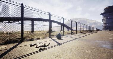 Abandoned industrial site with fence and distant mountains in daytime video